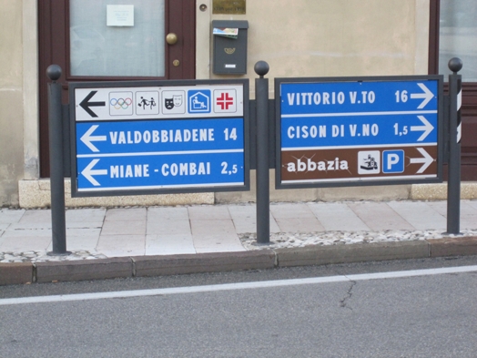 A photo of some blue street signs showing different directions of tourist attractions.