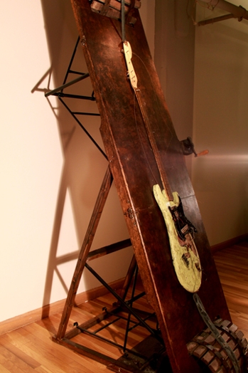 a painting of a guitar on a dark wood