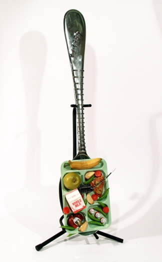 an electric guitar with the shape of a food tray with a spoon tail
