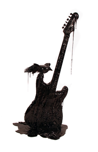 an electric guitar covered in mud with a small bird on it