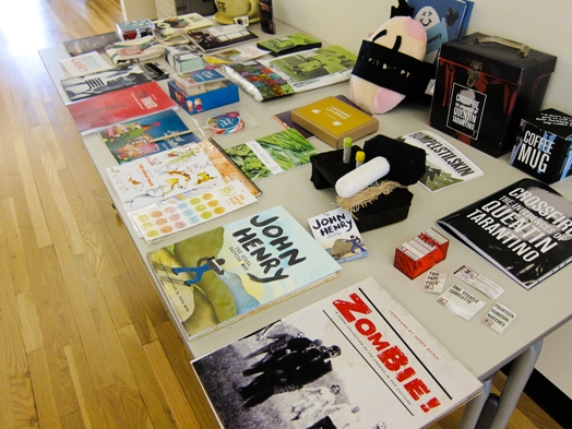 a table full of booklets and flyers and miscellaneous merchandise