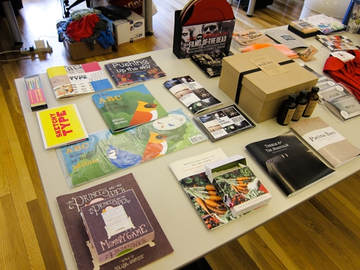 a table full of booklets and flyers and miscellaneous merchandise