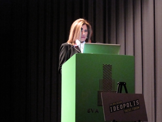 a woman giving a speech from a green stand