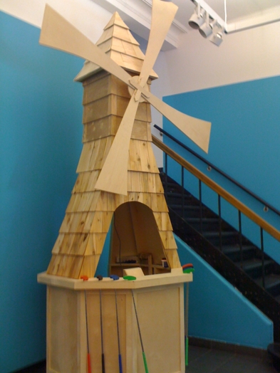a wood-made windmill with support for mini golf crosses