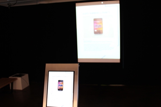 a close view of an iPad with its image projected on the wall in the background