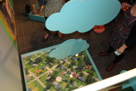 top-angle view of a city street image and clouds hanging from the ceiling made of plastic material