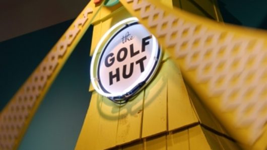 a yellow windmill with a circle containing "the GOLF HUT" writing