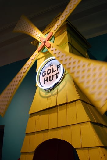 a yellow windmill with a circle containing "the GOLF HUT" writing