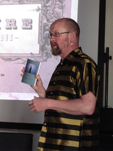 a man with black and gold strip shirt holding a book