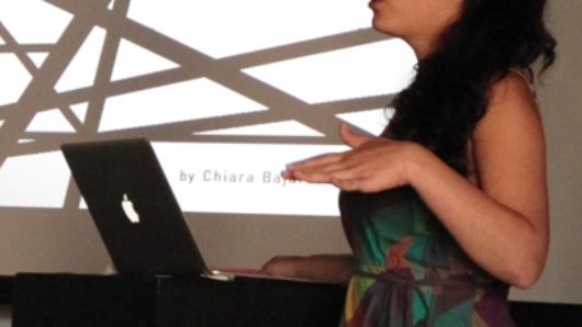 woman in colorful dress giving powerpoint presentation