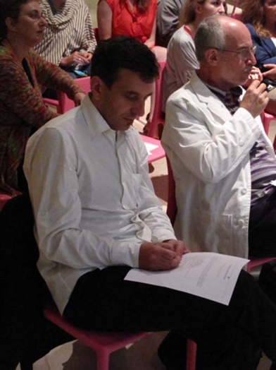 a man with a white shirt writing on a paper