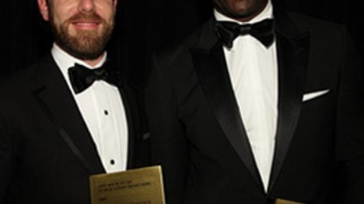 portrait of two men in black suits and white shirts