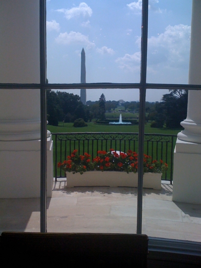 a view through the window to Washington Monument on a sunny day with a partially cloudy sky