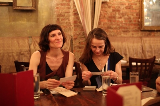 two women sitting at a table with card notes in their hands