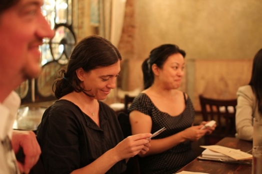 image of two women sitting at a table and reading card notes