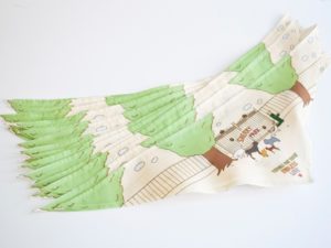 a stack of fabrics with tree and dogs illustrations