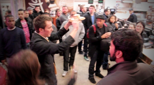 a crowd in the restaurant and a man holds up a plate