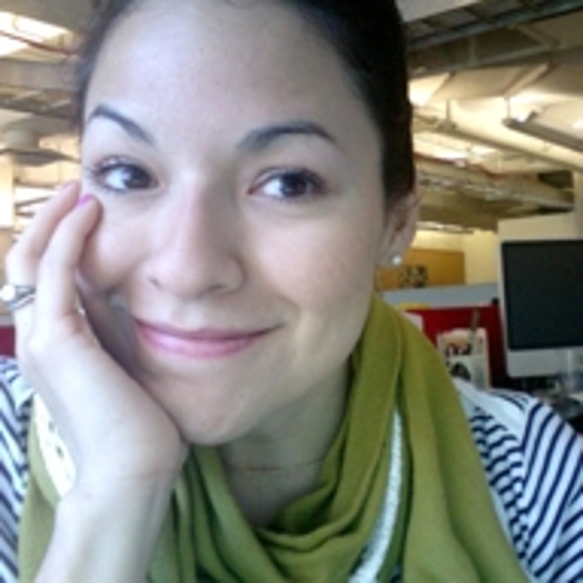 close portrait of a woman with a green scarf resting her head on her hand