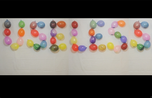 useless word composed of colored balloons mounted on a wall