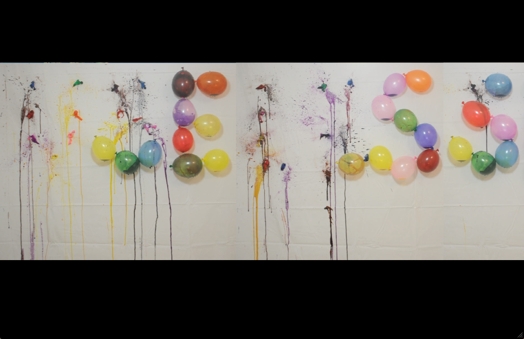 balloons forming a word on the wall and some of them are popped and they left behind paint draining down the wall