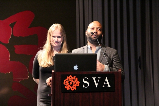 a man and a woman giving a speech from a stand in the "designer as" thesis presentation