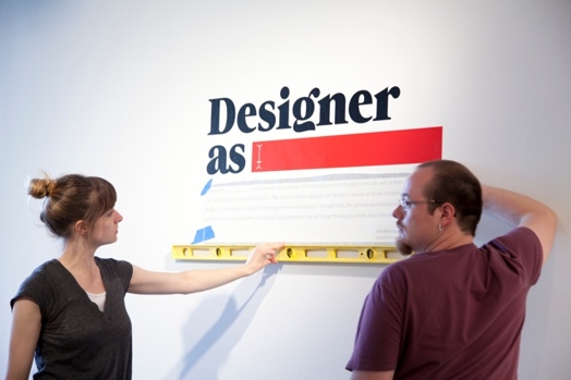 two people installing the designer as sticker on the wall