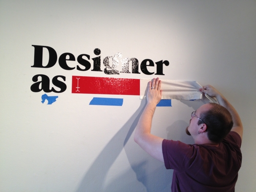 a man installing the designer as sticker on the wall
