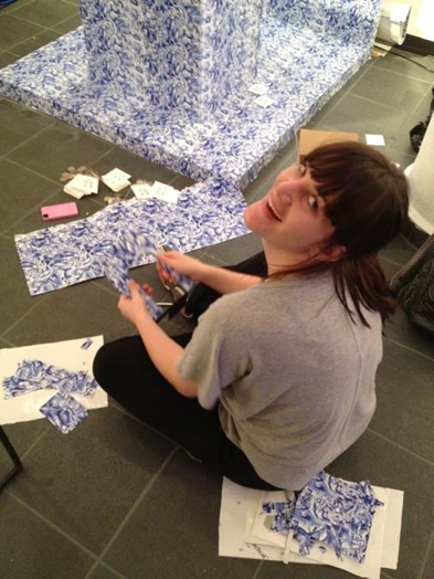 woman wrapping object in a paper with blue pattern