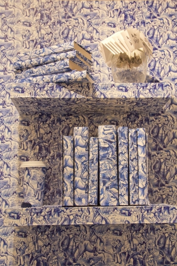 bookshelf with books and a coffee mug covered with a blue pattern