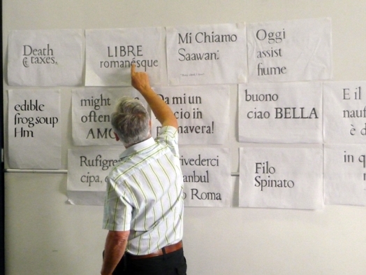 men pointing at typography on paper wall