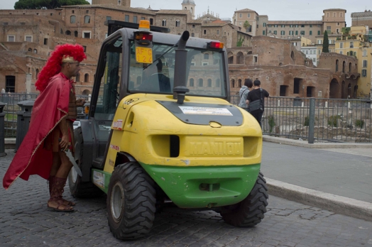 man with roman soldier costume entering a tractor with roman ruins in the back