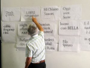men pointing at typography on wall filled with papers