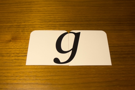 A photo of two card tiles forming the letter g.
