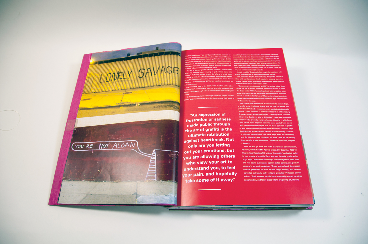 an opened book depicting a photo of a wall with the message Lonely savage on the left and a bunch of text paragraphs on the right side on red background