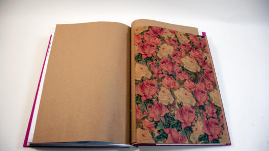 an opened book with a page with flower drawings on the right side