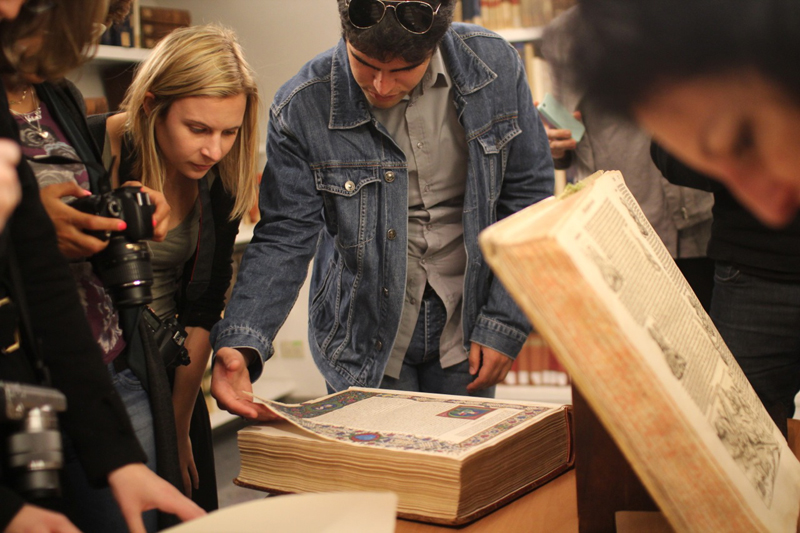 students looking at old book