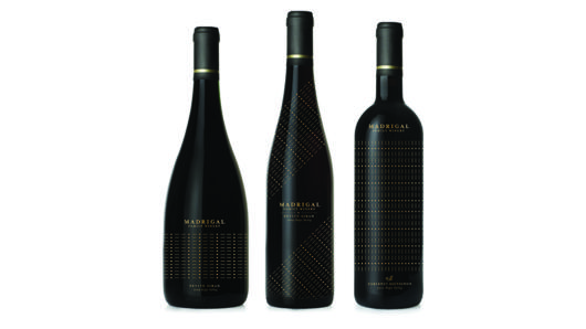 three black alcohol bottles with golden dots and text on the label