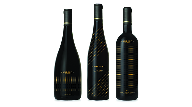 three black alcohol bottles with golden dots and text on the label