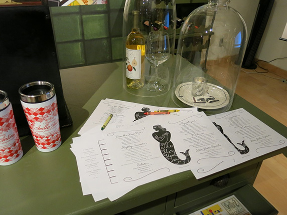 a table with papers, coffee mugs, and glass curved lids