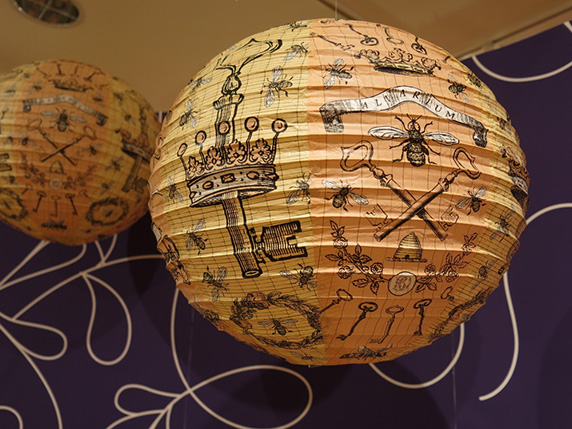 light globe made of yellow fabric with miscellaneous drawings on it