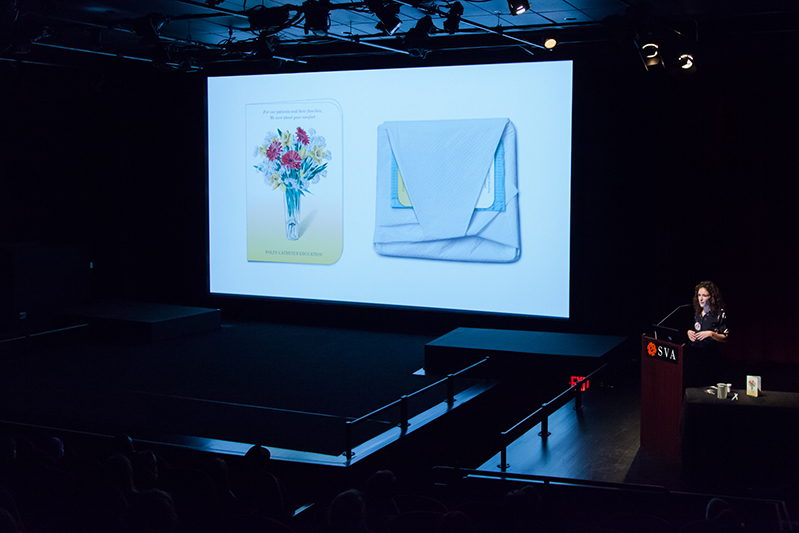 overview photo of a presentation with an image projected on a wall of a folded fabric and a book