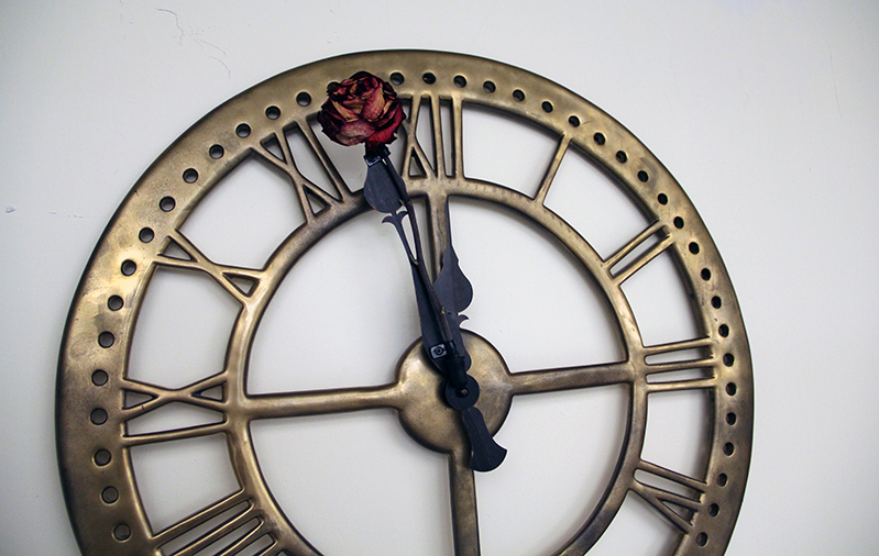 bronze clock with hour flower on the minute needle