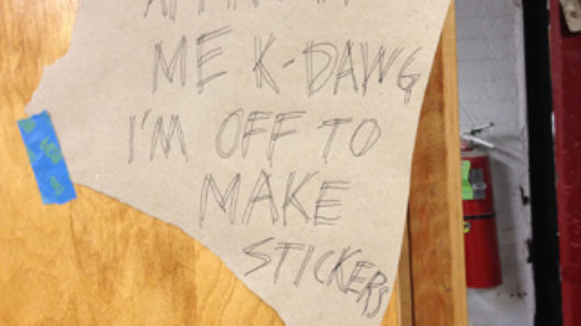 please approve me k-dawg i'm off to make stickers. written on a piece of paper stuck to a wood board