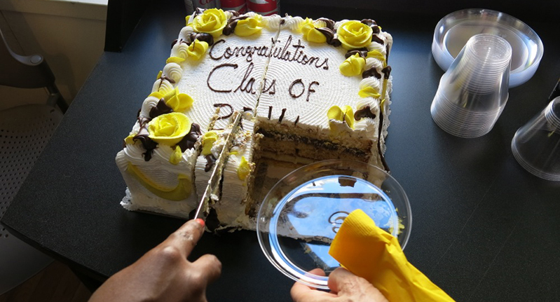 a person cutting a celebration cake with a knife