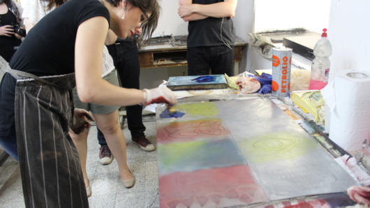 woman making a prints in studio with students watching