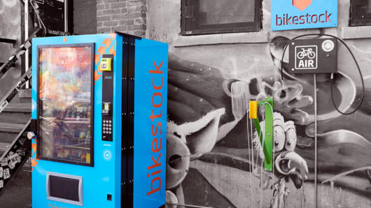 a vending machine with the bikestock logo in it and the logo installed on a wall beside the vending machine