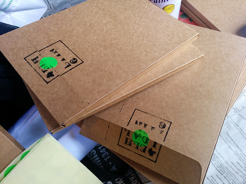 cardboard envelopes with black and green print