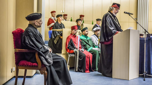 people wearing robes and one one is giving a speech