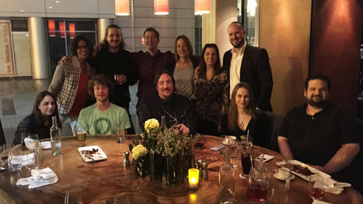 group portrait with people sitting at a table and a row of other people sitting behind those at the table