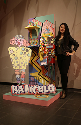 student standing in front of artwork